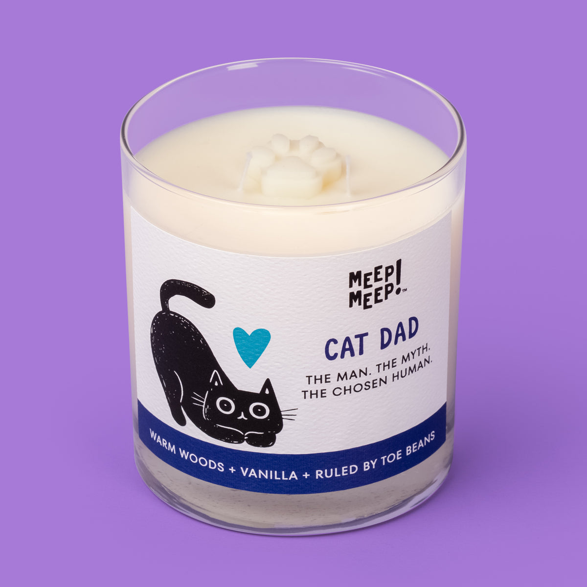 Meep Meep Cat Dad candle in a clear glass jar with a label featuring a stretching black cat and teal heart. Jar is angled so we can see the paw embed on top of candle.