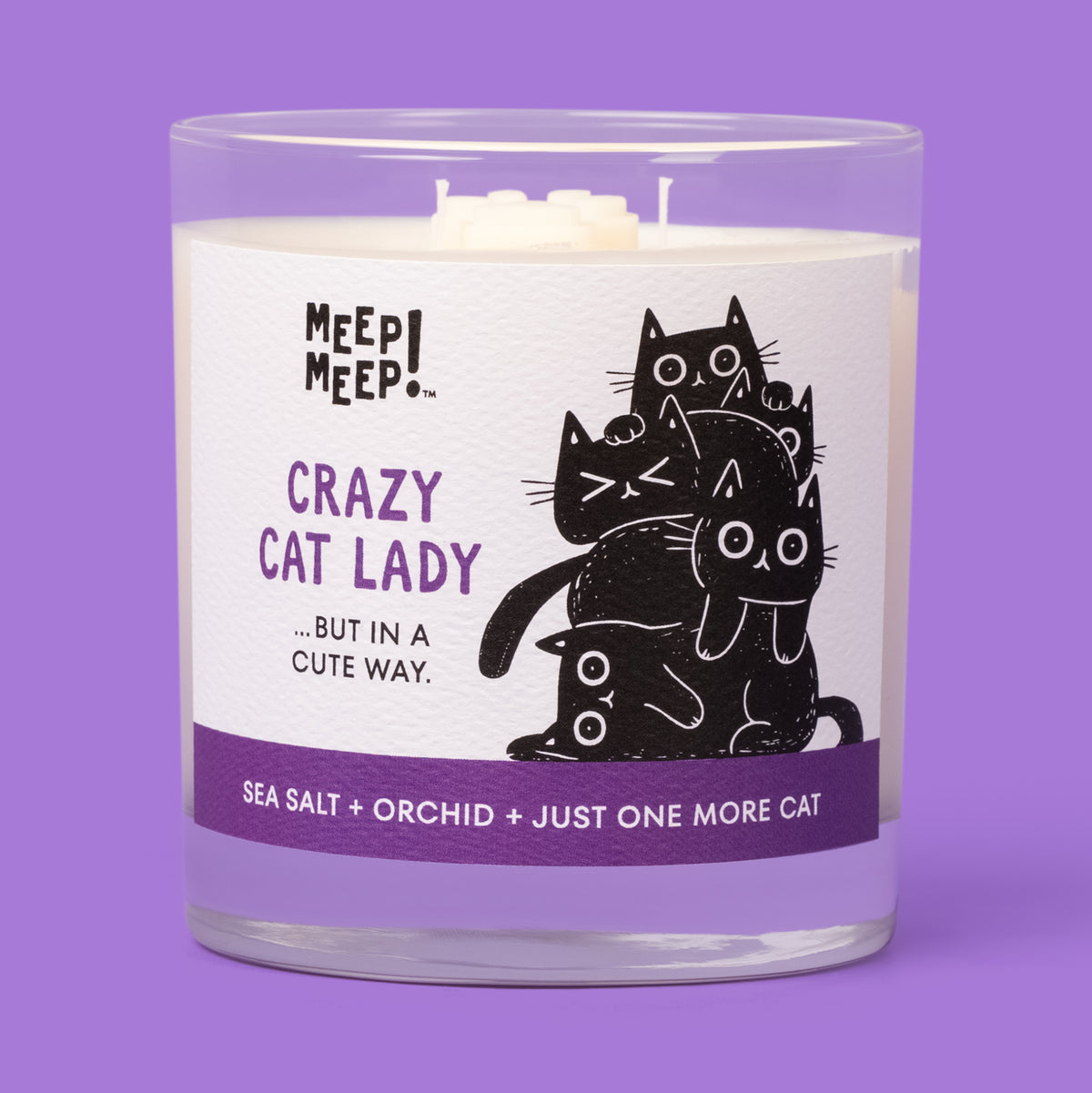 Meep Meep Crazy Cat Lady candle in a clear glass jar with a white and purple label showing a pile of black cats.